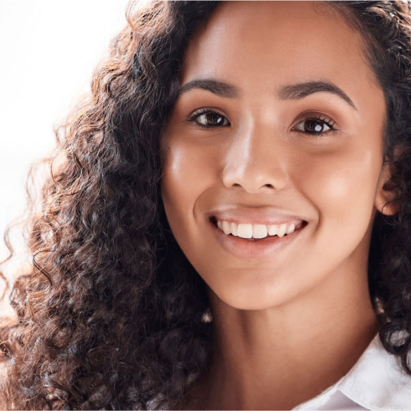 Smiling woman with clear, healthy eyes, representing relief after dry eye treatment.